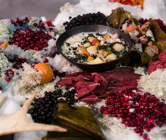 Arktik Mutfağı, Kuzey Kutup bölgesinde yaşayan Inuit, Sami ve diğer yerli halkların yüzyıllardır geliştirdiği yemek kültürünü ifade eder. Bu mutfak, zorlu iklim koşulları ve sınırlı doğal kaynaklarla şekillenmiş olup, hayatta kalmayı sağlayan pratik ve besleyici yemekleri içerir. Arktik mutfağı, sadece beslenme ihtiyacını karşılamakla kalmaz, aynı zamanda kültürel bir miras olarak nesiller boyunca aktarılır. Konulu bir haber görseli.