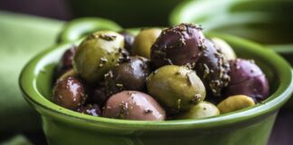 Baharatlı zeytin, Türkiye’de ve Akdeniz mutfaklarında uzun yıllardır sofraların baş köşesinde yer alıyor. Özellikle kahvaltılarda, meze sofralarında ve atıştırmalık olarak tercih edilen bu lezzet, yalnızca damak tadını zenginleştirmekle kalmıyor aynı zamanda sağlıklı beslenmenin de bir parçası oluyor. Farklı baharatlarla harmanlanan zeytinler, klasik tuzlu zeytinden çok daha aromatik bir tat sunuyor. Konulu bir haber görseli.