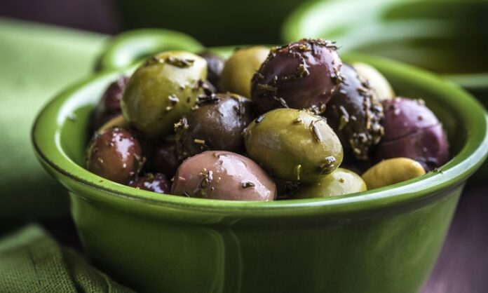 Baharatlı zeytin, Türkiye’de ve Akdeniz mutfaklarında uzun yıllardır sofraların baş köşesinde yer alıyor. Özellikle kahvaltılarda, meze sofralarında ve atıştırmalık olarak tercih edilen bu lezzet, yalnızca damak tadını zenginleştirmekle kalmıyor aynı zamanda sağlıklı beslenmenin de bir parçası oluyor. Farklı baharatlarla harmanlanan zeytinler, klasik tuzlu zeytinden çok daha aromatik bir tat sunuyor. Konulu bir haber görseli.