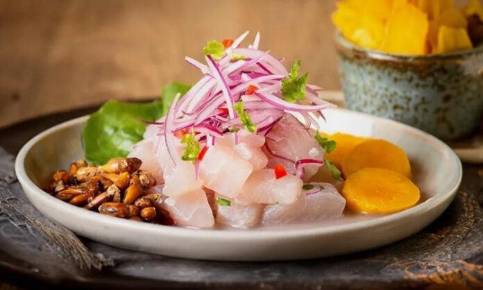 Ceviche, özellikle Güney Amerika mutfağının ikonik tariflerinden biridir ve taze balık veya deniz ürünlerinin asidik sıvılarla marine edilerek pişirilmeden servis edilmesi esasına dayanır. Ceviche, taze ve aromatik bir lezzet sunar ve yemeklerde hafif ama etkileyici bir tat deneyimi yaratır. Konulu bir haber görseli.