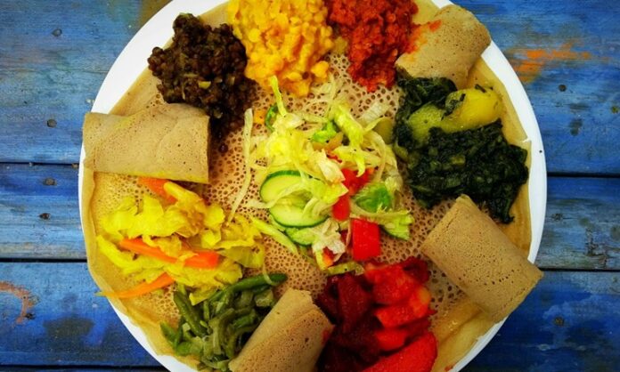 Etiyopya mutfağı, Afrika’nın doğusunda yer alan bu kadim ülkenin kültürel mirasını yansıtan eşsiz bir gastronomi deneyimi sunar. Bu mutfak, yüzyıllar boyunca farklı kültürlerin ve yerel geleneklerin bir araya gelmesiyle şekillenmiştir. Baharatlar, tahıllar ve sebzelerin yoğun kullanımı, Etiyopya yemeklerini hem lezzetli hem de besleyici kılar. Ülkenin farklı bölgelerinde yetişen malzemeler, yemeklerin her birine kendine özgü bir karakter kazandırır. Bu nedenle Etiyopya yemekleri, hem yerel halk hem de turistler tarafından büyük ilgi görmektedir. Konulu bir haber görseli.