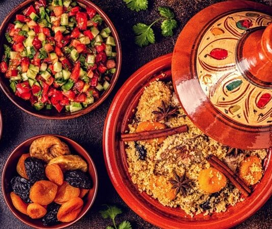 Fas Mutfağı yüzyıllar boyunca farklı kültürlerin etkileşimiyle şekillenmiş, hem görsel hem de lezzet açısından zengin bir gastronomi geleneğine sahiptir. Kuzey Afrika’nın bu eşsiz mutfağı, Arap, Berberi, Endülüs ve Fransız mutfaklarının harmanlanmasıyla ortaya çıkan özel tatlar sunar. Geleneksel tarifler, nesilden nesile aktarılan pişirme teknikleri ve yöresel baharatların uyumu, Fas yemeklerini dünya çapında tanınır hale getirmiştir. Bu mutfakta, baharatların ustaca kullanımıyla birlikte, yavaş pişirme yöntemleri ve özenle hazırlanmış soslar öne çıkar. Konulu bir haber görseli.