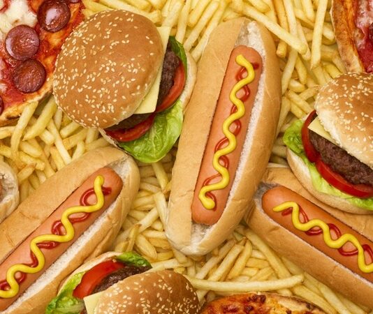 Günümüz şehir yaşamının yoğun temposu, yemek alışkanlıklarını da önemli ölçüde etkiledi. Fast food kültürü, hız ve pratiklik arayanların vazgeçilmez tercihlerinden biri haline geldi. Hamburgerden pizzaya, tavuk kanadından sandviçe kadar uzanan geniş bir yelpazede sunulan bu lezzetler, özellikle gençler arasında büyük ilgi görüyor. Konulu bir haber görseli.