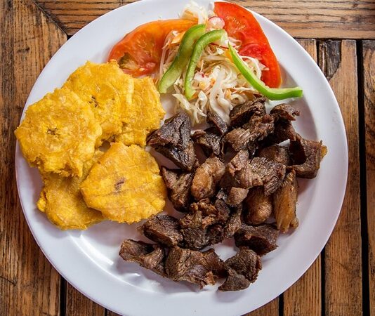 Haiti mutfağı, Afrika, Fransız ve Karayip kültürlerinin birleşimiyle oluşmuş, renkli ve lezzetli bir mutfaktır. Adanın tarihi, köle ticareti ve sömürge dönemleri, mutfağın karakterini şekillendirmiştir. Yemekler hem günlük yaşamda hem de özel kutlamalarda önemli bir yer tutar. Konulu bir haber görseli.