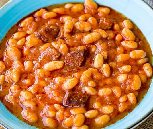 Türk mutfağının en sevilen yemeklerinden biri olan kuru fasulye, hem lezzeti hem de besleyici özellikleriyle sofralarda özel bir yere sahip. Yüzyıllardır Anadolu’nun dört bir yanında pişen bu klasik yemek, geleneksel tariflerden modern dokunuşlara kadar pek çok farklı şekilde hazırlanabiliyor. Özellikle bakliyatlar, uzun süre bozulmadan saklanabilmesi, yüksek protein ve lif içeriği ile hem ekonomik hem de sağlıklı bir besin kaynağı olarak öne çıkıyor. Konulu bir haber görseli.