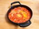 Menemen Türk Mutfağının Vazgeçilmez Kahvaltı Lezzeti Türk mutfağında kendine özel bir yer edinen menemen, hem pratik hazırlanışı hem de besleyici özelliğiyle sofraların vazgeçilmezlerinden biridir. Osmanlı döneminden günümüze uzanan kahvaltı kültüründe önemli bir rol oynayan bu yemek, özellikle Ege ve Akdeniz bölgelerinde daha da yaygın olarak tüketilmiştir. Domatesin tazeliği, biberin aroması ve yumurtanın kıvamıyla birleşerek ortaya çıkan bu eşsiz lezzet, zamanla tüm ülkeye yayılmıştır. Konulu bir haber görseli.