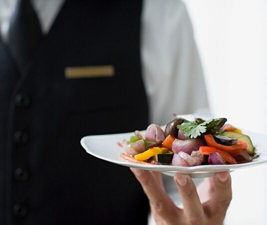 Yemek sadece karın doyurma eylemi değildir, aynı zamanda kültürel bir deneyimdir. Bu deneyimin en önemli parçalarından biri de servis sürecidir. Sofraya getirilen her tabağın düzeni, kullanılan tabak ve çatal-bıçak seçimi, hatta yemeklerin sırasıyla sunulması bile yemeğin nasıl algılandığını etkiler. Özellikle restoranlarda servis, müşteri memnuniyetini belirleyen en kritik unsurlardan biridir. Konulu bir haber görseli.