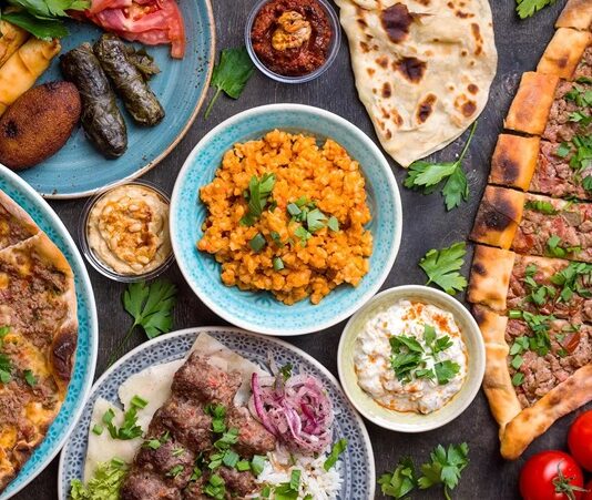 Orta Doğu Mutfağı, tarih boyunca farklı medeniyetlerin bir araya gelmesiyle şekillenmiş eşsiz bir mutfaktır. Persler, Osmanlılar, Arap kabileleri ve Akdeniz’in kadim uygarlıkları bu mutfağın gelişiminde önemli bir rol oynamıştır. Yüzyıllar boyunca ticaret yolları üzerinden taşınan baharatlar, otlar ve pişirme teknikleri Orta Doğu sofralarını zenginleştirmiştir. Bu nedenle bölgenin mutfak kültürü sadece yemek değil, aynı zamanda tarihsel bir miras olarak da görülmektedir. Konulu bir haber görseli.