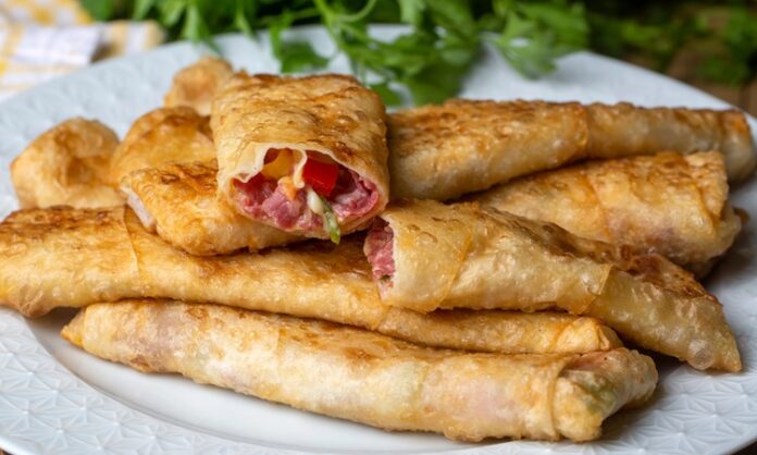 Paçanga böreği, Türk mutfağında özellikle kahvaltı ve çay saatlerinin vazgeçilmez lezzetlerinden biri olarak öne çıkıyor. İnce yufkanın içine kaşar peyniri, pastırma ve biber gibi malzemeler konularak hazırlanan bu börek, hem görselliği hem de lezzetiyle sofralarda özel bir yere sahip. Konulu bir haber görseli.