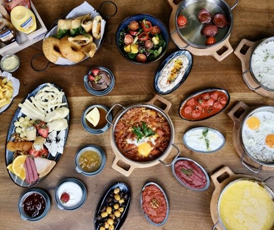 Serpme kahvaltı, Türk mutfağının en özel geleneklerinden biridir. Çeşitliliği, bereketi ve paylaşma kültürünü en iyi şekilde yansıtan bu kahvaltı türü, yalnızca yemek yemek için değil, aynı zamanda sevdiklerle bir araya gelmek için tercih edilir. Sofralara yayılan peynir çeşitleri, zeytin tabakları, bal, reçel ve sıcak çayla birleşen bu keyifli sunum, güne enerjik bir başlangıç yapmayı sağlar. Özellikle hafta sonları, ailelerin ve arkadaş gruplarının tercih ettiği serpme kahvaltılar, uzun sohbetlerin de vazgeçilmezidir. Konulu bir haber görseli.