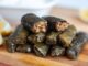 Sofralarda Sarma Ve Dolma Zenginliği Türk mutfağının en sevilen yemeklerinden olan sarma ve dolma, sofraların baş tacı olarak her dönemde yerini korur. Hem etli hem zeytinyağlı çeşitleriyle geniş bir yelpazeye sahip olan sarma ve dolma, kültürel mirasın lezzetli temsilcilerindendir. Genellikle üzüm yaprağı, lahana, biber, patlıcan gibi sebzeler kullanılarak hazırlanan bu yemekler, farklı iç harçlarıyla sofralara çeşitlilik ve zenginlik katar. Sofralarda sarma ve dolma, misafir sofralarında, özel günlerde ve günlük öğünlerde sıkça tercih edilir. Konulu bir haber görseli.