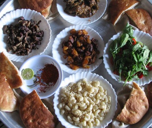 Sudan mutfağı, Afrika kıtasının doğusunda yer alan bu geniş coğrafyanın kültürel çeşitliliğini ve tarih boyunca oluşmuş etkileşimlerini sofralara taşıyan bir mirastır. Ülke, Nil Nehri’nin bereketli toprakları sayesinde tarım açısından zengin bir yapıya sahiptir ve bu durum mutfak kültürüne de doğrudan yansımaktadır. Sudan mutfağı aynı zamanda Arap, Afrika ve hatta Osmanlı etkilerinin bir arada hissedildiği bir gastronomi dünyası sunar. Bu nedenle Sudan’da sofraya oturduğunuzda yalnızca yemek değil, aynı zamanda tarih ve kültür de tatmış olursunuz. Konulu bir haber görseli.