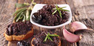 Tapenade, özellikle Fransız ve Akdeniz mutfağının vazgeçilmez zeytin ezmesi olarak biliniyor. Temel malzemeleri arasında siyah zeytin, kapari, zeytinyağı ve bazen ançüez bulunuyor. Bu malzemeler mutfak robotunda püre haline getirilerek homojen bir kıvam elde ediliyor. Hazırlanışı oldukça basit olsa da, malzemelerin kalitesi ve tazeliği ezmenin lezzetini doğrudan etkiliyor. Konulu bir haber görseli.