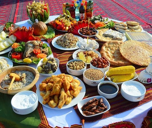 Türkmenistan mutfağı, Orta Asya’nın kurak ve çöl bölgelerinde göçebe yaşam tarzının etkisiyle şekillenmiş, hem pratik hem de besleyici yemeklerle öne çıkan bir mutfaktır. Tarih boyunca hayvancılık, tarım ve baharat kullanımı mutfağın temelini oluşturmuştur. Et ve tahıllar günlük beslenmenin başlıca öğeleri iken, sebzeler ve baharatlar yemeklere zengin bir tat ve aroma kazandırır. Konulu bir haber görseli.