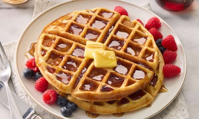 Waffle, özellikle kahvaltı ve tatlı sofralarının vazgeçilmez lezzetlerinden biri olarak biliniyor. İnce ve çıtır hamuru, kareli yapısı ve çeşitli soslarla sunulmasıyla sofralarda estetik bir görünüm oluşturuyor. Tarihsel olarak Avrupa kökenli olan waffle, zaman içinde Amerika ve Türkiye’de de yaygın bir tatlı ve atıştırmalık haline gelmiştir. Konulu bir haber görseli.