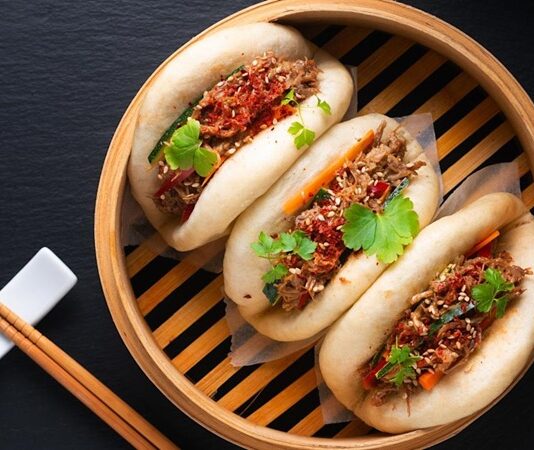 Bao Bun, Çin mutfağının en sevilen hamur işleri arasında yer alır. Yumuşacık dokusu ve farklı iç malzemeleriyle dikkat çeken bu lezzet, özellikle Uzak Doğu mutfağına meraklı olanların ilgisini çeker. Geleneksel olarak buharda pişirilen hamurdan yapılan Bao Bun, iç harcına göre etli, sebzeli veya tatlı alternatiflerle hazırlanabilir. Kökeni Çin’in kuzey bölgelerine dayanan bu yiyecek, yüzyıllar boyunca hem halk sofralarında hem de özel günlerde kendine yer bulmuştur. Konulu bir haber görseli.