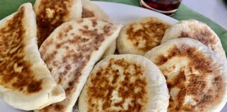 Türk mutfağının en özel ve sevilen ekmek çeşitlerinden biri olan bazlama, yumuşak dokusu, doyurucu yapısı ve mis gibi kokusuyla sofraların vazgeçilmezidir. Özellikle Anadolu’nun birçok bölgesinde kahvaltıların, çay saatlerinin ve hatta ana yemeklerin yanında sıklıkla tercih edilen bu ekmek, sadece lezzetiyle değil kültürel bir değer olarak da öne çıkar. Günümüzde modern sofralarda da kendine yer bulan bazlama, hem geleneksel hem de pratik bir lezzet olarak dikkat çekmektedir. Konulu bir haber görseli.