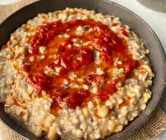 Etli keşkek, Türk mutfağının en köklü ve geleneksel yemeklerinden biri olarak bilinir. Yüzyıllardır düğünlerde, bayramlarda ve özel davetlerde sofraların baş tacı olmuştur. Anadolu’nun farklı yörelerinde kendine özgü tariflerle hazırlanması, yemeğin zengin kültürel mirasını gözler önüne serer. Konulu bir haber görseli.