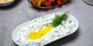Haydari, özellikle kahvaltı sofralarının ve mezelerin vazgeçilmez tatlarından biridir. Yoğurt bazlı bu lezzetli meze, hem hafif hem de besleyici olmasıyla öne çıkar. Haydari, yüksek protein içeriği sayesinde kas ve kemik sağlığını desteklerken, probiyotik özelliği ile sindirim sistemine katkıda bulunur. İçerdiği sarımsak ve dereotu gibi doğal malzemeler, lezzetin yanı sıra sağlık açısından da avantaj sağlar. Konulu bir haber görseli.