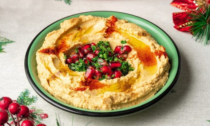 Humuslu Sandviç, geleneksel Ortadoğu lezzeti humusun taze ekmek veya lavaş arasına konularak hazırlandığı pratik bir öğün seçeneğidir. Protein ve lif açısından zengin olan humus, nohut bazlı yapısı sayesinde doyurucu ve besleyici bir alternatiftir. Sandviçlerin içine domates, salatalık, marul, biber ve çeşitli yeşillikler eklenerek vitamin değerleri artırılır. Konulu bir haber görseli.