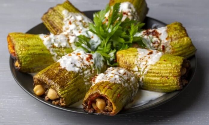 Türk mutfağının vazgeçilmezlerinden biri olan kabak dolması, hafifliği ve besleyici özelliğiyle yüzyıllardır sofralarda kendine özel bir yer edinmiştir. Anadolu’nun bereketli topraklarında yetişen taze kabaklarla hazırlanan bu yemek, hem günlük öğünlerde hem de özel davetlerde tercih edilen lezzetler arasında bulunur. Dolma kültürünün önemli temsilcilerinden biri olan kabak dolması, sağlıklı ve doyurucu yönüyle her yaştan insanın ilgisini çeker. Konulu bir haber görseli.