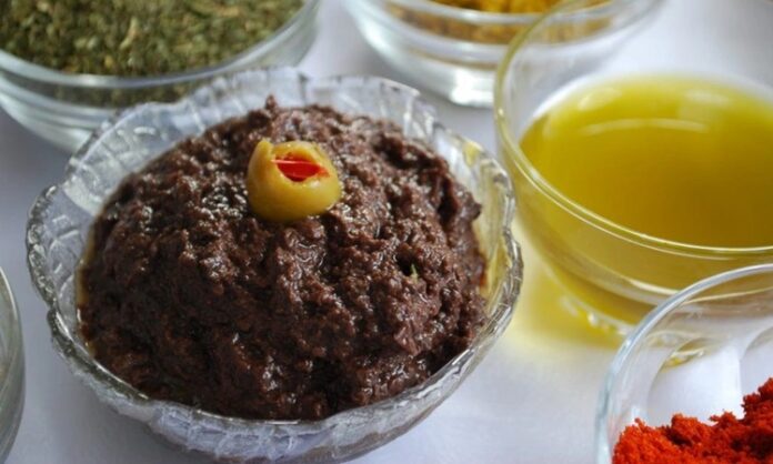 Zeytin ezmesi, yüzyıllardır özellikle Akdeniz mutfak kültüründe kendine özel bir yer edinmiş sağlıklı bir lezzettir. Anadolu’da kahvaltı sofralarının vazgeçilmezi olarak bilinen bu eşsiz tat, sadece kahvaltılarda değil farklı yemeklerin yanında da tüketilmektedir. Zeytin ağacının binlerce yıllık geçmişi, bu ürünü adeta bir kültürel miras haline getirmiştir. Bu nedenle, özellikle köylerde yapılan doğal yöntemlerle hazırlanmış zeytin ezmesi, sofralarda hem lezzeti hem de sağlık açısından sunduğu faydalar ile tercih edilmektedir. Konulu bir haber görseli.