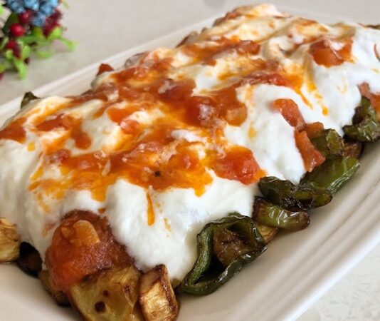 Köpoğlu, özellikle Ege ve Akdeniz mutfaklarının sevilen mezelerinden biridir ve hem lezzeti hem de besleyici içeriği ile öne çıkar. Köpoğlu, közlenmiş patlıcan, yoğurt, sarımsak ve zeytinyağı ile hazırlanan, hafif ama doyurucu bir mezedir. İçerdiği patlıcan sayesinde lif açısından zengin olan köpoğlu, sindirim sistemini destekler ve tokluk hissi yaratır. Yoğurt ise protein ve probiyotik içerir, bağışıklık sistemine katkıda bulunur. Konulu bir haber görseli.