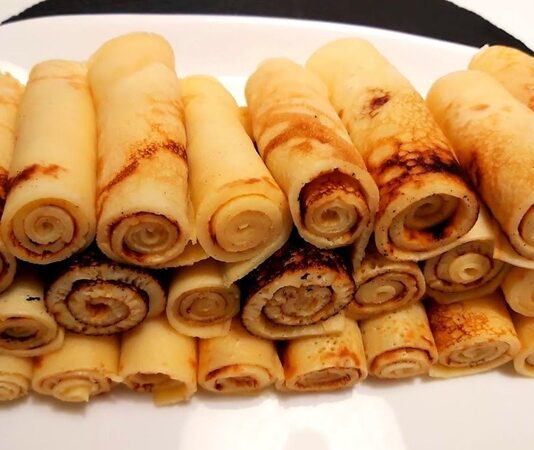 Krep rulo, hem kahvaltılarda hem de ara öğünlerde pratik ve lezzetli bir seçenek olarak öne çıkıyor. İnce krep hamurunun içine peynir, sebze, et veya reçel gibi farklı malzemeler konularak hazırlanan bu atıştırmalık, hem göze hem de damağa hitap ediyor. Krep rulo, sadece lezzeti ile değil, sunum açısından da sofraları zenginleştiriyor. Bu yazımızda krep rulo yapımından sunum önerilerine, malzeme çeşitlerinden sağlıklı alternatiflere kadar her detayı detaylı olarak inceleyeceğiz. Konulu bir haber görseli.