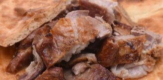 Türk mutfağında yüzyıllardır önemli bir yere sahip olan kuzu tandır, Osmanlı döneminden günümüze uzanan köklü bir geleneğin parçasıdır. Adını pişirme yönteminden alan bu yemek, geçmişte toprak tandırlarda ağır ateşte uzun süre pişirilerek hazırlanırdı. Bu yöntem, etin hem yumuşacık olmasını sağlar hem de lezzetinin doğal kalmasına yardımcı olurdu. Bugün ise modern mutfaklarda fırınlarda ya da özel kaplarda hazırlanarak sofralara taşınmaktadır. Konulu bir haber görseli.