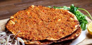 Türk mutfağının en sevilen lezzetlerinden biri olan lahmacun, yüzyıllardır sofralarda kendine yer bulmaktadır. İnce açılmış hamurun üzerine kıyma, domates, soğan, maydanoz ve çeşitli baharatlarla hazırlanan iç harcın eklenmesiyle pişirilen bu eşsiz yemek, hem lezzeti hem de pratikliğiyle öne çıkar. Anadolu’nun farklı bölgelerinde yaygın olarak tüketilen lahmacun, özellikle Güneydoğu mutfağının vazgeçilmezleri arasında yer almaktadır. Konulu bir haber görseli.