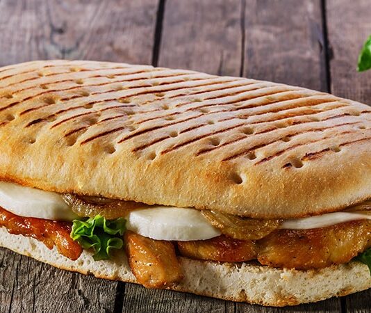 Panini, İtalyan mutfağının en sevilen ve hızlı atıştırmalık seçeneklerinden biridir. Kelime anlamı olarak “küçük ekmekler” anlamına gelen panini, İtalya’da özellikle öğle yemeklerinde tercih edilir. Geleneksel olarak ciabatta veya focaccia ekmeği kullanılarak hazırlanan panini, peynir, et ve sebzelerle zenginleştirilir. Konulu bir haber görseli.