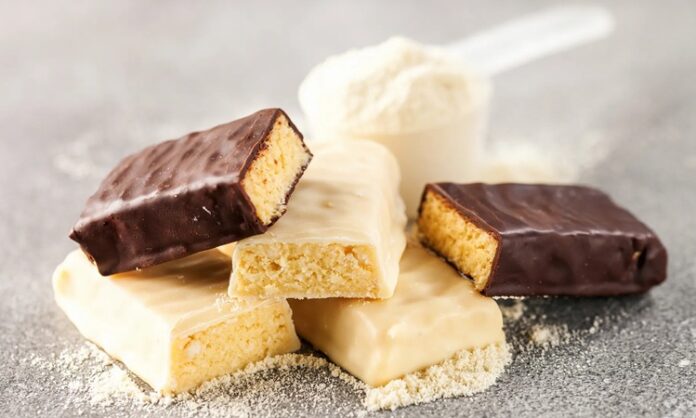 Günümüzde protein barlar, sporcular, yoğun çalışanlar ve sağlıklı beslenmeyi tercih eden kişiler arasında giderek popülerleşiyor. Bu barlar, pratik ve taşınabilir yapıları sayesinde, hızlı enerji ve protein ihtiyacını karşılamak için ideal bir seçenek sunuyor. Protein barlar, özellikle spor sonrası kas onarımı ve tok kalma süresi açısından önemli bir rol oynuyor. Konulu bir haber görseli.