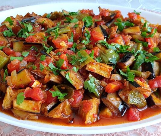 Şakşuka, özellikle Türk mutfağının sevilen sebze yemeklerinden biridir ve hem görselliği hem de lezzeti ile öne çıkar. Şakşuka, kızartılmış patlıcan, biber, domates ve sarımsak ile hazırlanan, hafif ve besleyici bir yemektir. İçerdiği sebzeler, vitamin ve mineral açısından zengin olduğu için vücuda enerji sağlar ve bağışıklık sistemini destekler. Zeytinyağı ile yapılan şakşuka, sağlıklı yağ alımını destekler ve kalp sağlığına katkıda bulunur. Konulu bir haber görseli.