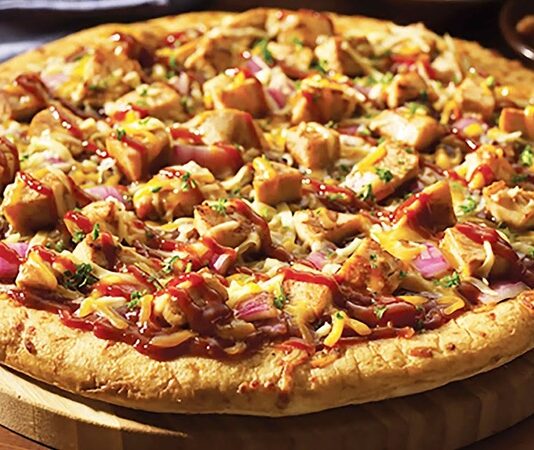 Tavuklu Pizza: Lezzetli ve Pratik Bir Seçenek Tavuklu Pizza Tarihi Ve Kökeni Tavuklu pizza, klasik İtalyan pizzalarından türeyen modern ve lezzetli bir alternatiftir. Tavuk etinin pizzaya eklenmesi, hem protein açısından zengin bir öğün sunar hem de farklı tat kombinasyonları yaratır. İlk olarak Amerika’da popüler hale gelen tavuklu pizza, günümüzde dünya genelinde restoran menülerinde sıkça yer alıyor. Tavuklu pizzanın popülerliği, özellikle hızlı ve dengeli bir öğün arayanlar için idealdir. Restoranlar ve ev mutfaklarında hazırlanan bu pizza, taze malzemelerle birleştiğinde hem göze hem damağa hitap eder. Tavuk, pizza kültürüne yenilik katan bir unsur olarak öne çıkar. Tavuklu Pizza Malzemeleri Ve Hazırlık Süreci Evde veya restoranlarda yapılan tavuklu pizza, hamur, domates sosu, peynir ve tavuk eti ile hazırlanır. Tavuk parçaları, önceden marine edilip sotelenerek pizzaya eklenebilir. Bu işlem, tavuğun hem lezzetini artırır hem de yumuşak bir doku sağlar. Pizzada kullanılan sebzeler de lezzeti tamamlar. Biber, mantar, soğan veya mısır gibi malzemeler tavukla uyum sağlar. Mozzarella veya cheddar peyniri, tavuk ve sebzelerle birleşerek zengin bir tat deneyimi sunar. Hamurun kabarması ve fırın sıcaklığı, pizzanın çıtır ve lezzetli olmasında kritik rol oynar. Restoranlarda Tavuklu Pizza Deneyimi Profesyonel mutfaklarda tavuklu pizza, hem görsellik hem de lezzet açısından özenle hazırlanır. Tavuk parçaları eşit dağıtılarak pizzaya eklenir ve fırınlanır. Fırın sıcaklığı, tavuk etinin kurumasını engeller ve pizza hamurunun ideal dokuda olmasını sağlar. Bazı restoranlar tavuklu pizzayı baharatlı soslarla veya farklı peynir çeşitleriyle sunarak özgün tatlar yaratır. Bu sayede pizza, klasik lezzetinden ayrılarak daha sofistike bir hale gelir. Tavuklu pizza, hem hızlı hem de doyurucu bir öğün alternatifi olarak öne çıkar. Evde Tavuklu Pizza Yapmanın Püf Noktaları Evde yapılan tavuklu pizza, malzeme seçimi ve hazırlık süreci ile fark yaratır. Hamur ne çok ince ne de çok kalın olmalıdır; bu denge pizzanın dokusunu belirler. Tavuk etinin önceden marine edilmesi ve uygun şekilde pişirilmesi, pizzanın lezzetini artırır. Sebzeler ve peynir, tavukla uyumlu şekilde eklenmelidir. Mozzarella peyniri, tavuk parçalarının üzerinde eriyerek hem lezzet hem de görsellik sağlar. Fırın sıcaklığı genellikle 220-250 derece arasında olmalı ve pişirme süresi hamurun kalınlığına göre ayarlanmalıdır. Tavuklu Pizza Çeşitleri Tavuklu pizza, malzeme kombinasyonuna göre farklılık gösterir. Barbekü soslu, acılı tavuklu, mantarlı ve sebzeli seçenekleri bulunur. Bu çeşitler pizzayı hem lezzet hem de besin değeri açısından zenginleştirir. Diyet tercihlerine göre glutensiz hamur veya az yağlı peynir kullanarak evde tavuklu pizza hazırlamak mümkündür. Bu alternatifler, sağlıklı beslenme alışkanlığına önem verenler için idealdir. Tavuklu pizza, hem klasik hem de modern damak zevklerine hitap eder. Tavuklu Pizza Sağlık Açısından Temel malzemeleri tavuk ve sebzeler olan tavuklu pizza, dengeli bir öğün alternatifi oluşturur. Tavuk eti protein açısından zengindir ve kas gelişimini destekler. Sebzeler ise vitamin, mineral ve lif sağlar. Peynirler de kalsiyum ve protein içererek öğünü tamamlar. Evde yapılan tavuklu pizzada yağ ve tuz miktarının kontrol edilmesi, daha sağlıklı bir seçenek sunar. Taze sebzeler ve kaliteli tavuk kullanımı, pizzayı hem lezzetli hem de besleyici bir öğün haline getirir. Tavuklu Pizza Kültürü ve Popülerliği Tavuklu pizza, dünya genelinde pizza kültürünün modern ve sağlıklı alternatiflerinden biri olarak öne çıkıyor. Restoranlardan ev mutfaklarına kadar her yerde bulunabilir. Tavuklu pizzanın popülerliği, hem hızlı hem de doyurucu bir öğün arayanlar için vazgeçilmez bir seçenek olmasını sağlıyor. Restoran zincirlerinden butik pizzacılara kadar pek çok yerde sunulan tavuklu pizza, klasik pizza türleri arasında kendine özel bir yer edinmiştir. Tavuk etinin ve malzemelerin tazeliği, pizzayı her yaştan tüketici için cazip kılar ve pizza kültürünü daha zengin bir hale getirir. Konulu bir haber görseli.