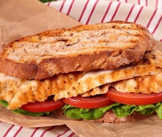 Tavuklu sandviç, günümüzde en çok tercih edilen pratik öğünlerden biri olarak öne çıkar. Kökeni, 20. yüzyılın başlarına kadar uzanan bu sandviç, hızlı hazırlanan ve doyurucu bir yemek alternatifi olarak popülerlik kazanmıştır. İlk olarak Amerika ve Avrupa’da yaygınlaşan tavuklu sandviç, kısa sürede dünya mutfaklarında standart bir seçenek haline gelmiştir. Konulu bir haber görseli.