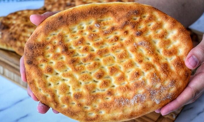 Tırnak Pide Gelenekten Günümüze Uzanan Lezzet Türk mutfağının en sevilen ekmek çeşitlerinden biri olan tırnak pide, özellikle Ramazan sofralarının ve kebapçıların vazgeçilmez lezzetleri arasında yer alır. Yumuşak içi ve hafif çıtır kabuğu ile öne çıkan bu pide, hem sade olarak hem de farklı yemeklerin eşlikçisi şeklinde tüketilir. Tırnak pide, adını hamura parmak uçlarıyla yapılan tırnak izlerinden alır ve bu izler pişirme sırasında pideye özgün bir görünüm kazandırır. Hem görselliği hem de tadıyla sofraları süsleyen bu geleneksel lezzet, Anadolu’nun mutfak kültüründe önemli bir yere sahiptir. Konulu bir haber görseli.