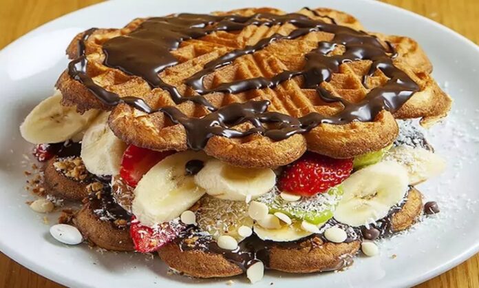 Waffle, Belçika kökenli, çıtır dışı ve yumuşak içi ile bilinen tatlı hamur ürünüdür. Orta Çağ’dan bu yana Avrupa’da tüketilen bu lezzet, zamanla Amerika ve diğer kıtalara yayılmıştır. Geleneksel olarak kahvaltıda veya tatlı saatlerinde tercih edilen waffle, taze meyve, çikolata veya karamel sosla servis edilir. Konulu bir haber görseli.