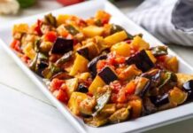 Zeytinyağlı patlıcan, Türk mutfağının klasik lezzetlerinden biri olarak sofralarda uzun yıllardır yerini koruyor. Hem hafif hem de besleyici bir seçenek olması nedeniyle özellikle sağlıklı beslenmeyi tercih edenlerin favorisi hâline gelmiştir. Patlıcanın yumuşak dokusu ve zeytinyağının aroması birleşerek lezzetli bir yemek ortaya çıkarır. Konulu bir haber görseli.