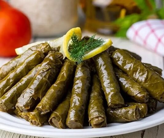 Zeytinyağlı yaprak sarma, Türk mutfağının en sevilen geleneksel lezzetlerinden biridir. Özellikle meze olarak sofralarda sıkça yer alır ve hem hafif hem de besleyici bir alternatif sunar. Yaprak sarması, sadece Türkiye’de değil, Orta Doğu ve Balkan mutfaklarında da farklı yorumlarla hazırlanır. Konulu bir haber görseli.