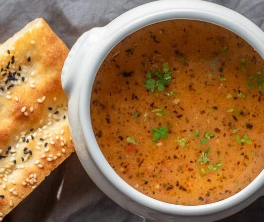 Türkiye’nin en köklü geleneklerinden biri olan tarhana çorbası, son yıllarda yeniden yükselişe geçen klasik tatlar arasında dikkat çekiyor. Anadolu’nun yüzlerce yıllık fermente gıda kültürünün en güçlü temsilcilerinden biri olan tarhana, özellikle kış aylarının yaklaşmasıyla birlikte hem ev mutfaklarında hem de restoranlarda daha fazla tercih edilmeye başlandı. Uzmanlar, tarhananın doğal fermantasyon süreci sayesinde güçlü bir probiyotik kaynağı olduğunu belirtiyor ve bu nedenle özellikle soğuk havalarda bağışıklık sistemini desteklediğini vurguluyor. Sağlıklı beslenme trendlerinin artmasıyla birlikte tarhana çorbası hem geleneksel hem de modern bir şifa kaynağı olarak yeniden gündemde. Konulu bir haber görseli.