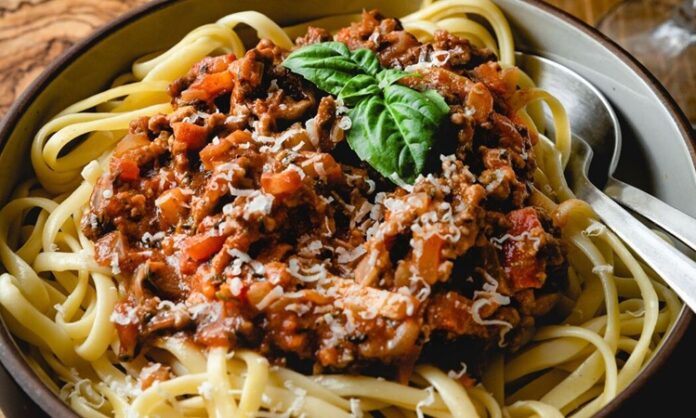 Klasik İtalyan Mutfağının Taçsız Kralı Spagetti Bolonez'in Sırrı ve Hikayesi Spagetti Bolonez, dünya mutfaklarının en popüler ve sevilen yemeklerinden biridir. İtalya'nın Bolonya bölgesinden çıkan bu klasik tarif, sadece bir yemek olmaktan öte, nesiller boyu aktarılan bir mutfak kültürü mirasıdır. Basit gibi görünse de, gerçek bir Bolonez sosu hazırlamak, sabır, doğru malzemeler ve belirli pişirme teknikleri gerektirir. Bu lezzetli yemeğin ardındaki derin hikayeyi ve onu bu kadar özel yapan incelikleri keşfetmeye hazır olun. Konulu bir haber görseli.