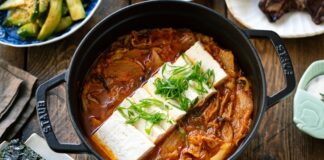 Güney Kore mutfağının en ikonik çorbalarından biri olan Kimchi Jjigae, son yıllarda dünya genelinde hem restoran menülerinde hem de ev yapımı tariflerde popülerliğini artırıyor. Özellikle fermente lahana, baharatlı biber ve dengeli et suyu ile hazırlanan bu çorba, hem doyurucu hem de sağlık açısından zengin bir yemek olarak öne çıkıyor. Türkiye’de de gastronomi meraklılarının ilgisini çeken Kimchi Jjigae, Kore mutfağının globalleşmesinde önemli bir rol oynuyor. Lezzeti ve besleyici özellikleri sayesinde çorba severler için hem geleneksel hem de modern alternatifler sunuyor. Konulu bir haber görseli.