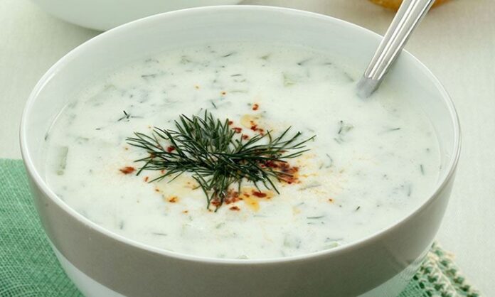 Cacık, Türk mutfağının en sevilen ve ferahlatıcı tariflerinden biri olarak öne çıkıyor. Özellikle yaz aylarında sofraları süsleyen bu yoğurt bazlı karışım, hem hafif hem de besleyici bir seçenek olarak dikkat çekiyor. Cacık hem öğle yemeklerinin yanında hem de akşam yemeklerinde meze olarak sunulabiliyor. Taze nane, salatalık ve sarımsak gibi malzemelerle hazırlanan cacık, sağlıklı ve lezzetli oluşuyla mutfakların vazgeçilmezi haline geliyor. Konulu bir haber görseli.