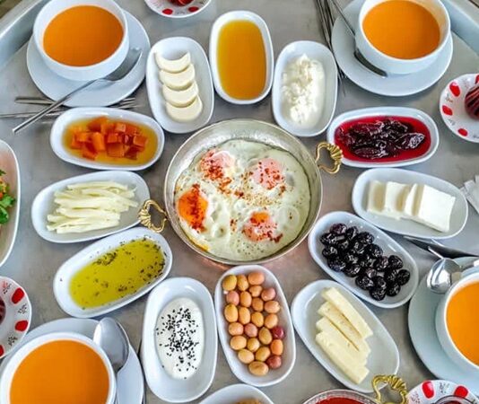 Anadolu’nun en güçlü kültürel sembollerinden biri olan köy sofrası, yalnızca yemek yenen bir alan değil; paylaşmanın, dayanışmanın ve doğallığın somutlaştığı bir yaşam pratiğidir. Toprakla iç içe bir hayatın ürünü olan bu sofralar, mevsimin sunduğu nimetleri ve emeğin karşılığını bir araya getirir. Köy sofrasında gösterişten çok samimiyet, çeşitlilikten çok bereket ön plandadır. Bu nedenle köy sofrası, şehir hayatında giderek özlenen bir değer hâline gelmiştir. Konulu bir haber görseli.