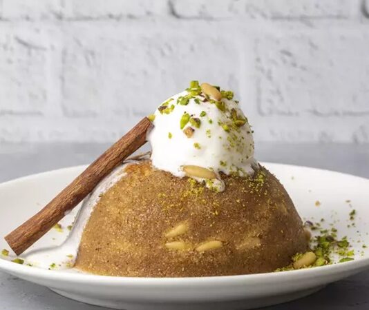 Türk mutfağının en köklü tatlılarından biri olan irmik helvası, yıllar içinde farklı yorumlarla sofralardaki yerini korurken dondurmalı irmik helvası bu dönüşümün en dikkat çekici örneklerinden biri olarak öne çıkıyor. Sıcak helvanın yoğun ve doyurucu yapısı ile dondurmanın serinletici etkisini bir araya getiren bu tatlı, hem geleneksel damak zevkine hitap ediyor hem de modern sunum anlayışıyla yeni nesil tüketicilerin ilgisini çekiyor. Özellikle restoran ve lokantalarda sıkça karşımıza çıkan bu lezzet, klasik bir tatlının nasıl yeniden yorumlanabileceğini gösteren güçlü bir örnek olarak kabul ediliyor. Konulu bir haber görseli.