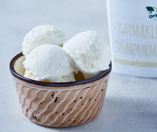 Türk mutfağının köklü tatlı geleneği içinde özel bir yere sahip olan kaymaklı dondurma, geçmişten günümüze uzanan lezzetiyle hem yerel hem de modern sofralarda kendine sağlam bir yer edinmiştir. Süt ve kaymağın yoğun aromasıyla hazırlanan bu dondurma türü, sade yapısına rağmen güçlü bir tat profili sunar. Özellikle doğal ve katkısız tatlı arayışında olanların tercihi hâline gelen kaymaklı dondurma, damakta bıraktığı kalıcı lezzetle dikkat çeker. Konulu bir haber görseli.