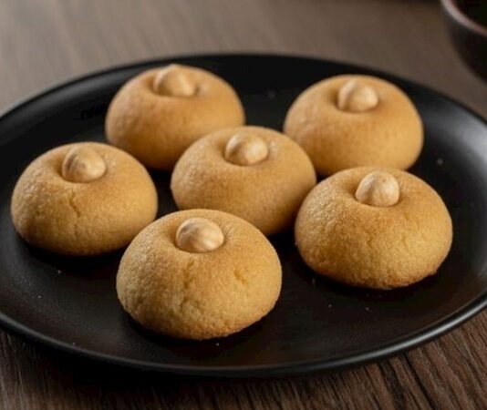 Türk mutfağı, yıllardır süre gelen tatlı geleneğini en özgün şekilde yansıtan pek çok tarifle dolu. Bu tariflerden biri de görünümüyle bile ayrı bir merak uyandıran hanım göbeği tatlısı. Şerbetli tatlılar arasında özel bir yere sahip olan bu tatlı, hem hafif yapısıyla hem de geleneksel malzemeleriyle sofralarda yer bulmaya devam ediyor. Anadolu’nun birçok şehrinde özellikle bayramlarda, özel günlerde ve misafir sunumlarında tercih edilen hanım göbeği tatlısı, günümüzde evlerde daha pratik yöntemlerle uygulanabilir hale geldi. Konulu bir haber görseli.