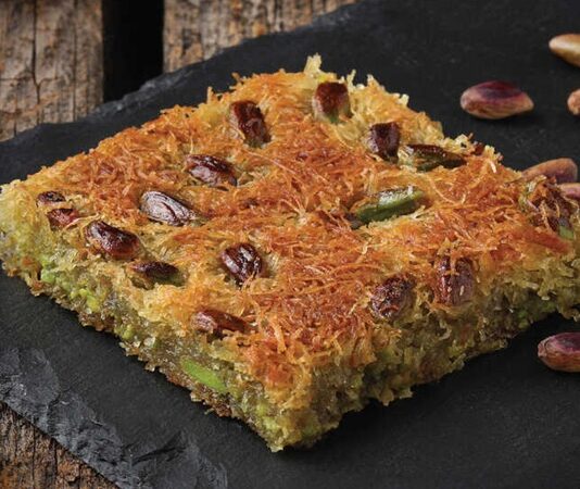 Türkiye’nin en sevilen tatlılarından biri olan kadayıf, hem köklü geçmişi hem de zengin lezzet yapısıyla uzun bir kültürel geleneğin temsilcisi konumunda bulunuyor. Osmanlı döneminde saray mutfağının önemli tatlıları arasında kabul edilen kadayıf, özellikle Ramazan ve bayram dönemlerinde sofraların en çok tercih edilen tatlılarından biri hâline gelmiştir. Bu tatlı, Ortadoğu’dan Balkanlara kadar geniş bir coğrafyada kendine yer edinmiş, her bölgenin damak tadına ve kültürel alışkanlıklarına göre farklı tariflerle yeniden şekillenmiştir. Bu nedenle kadayıf, sadece tatlı olarak değil bir kültürel aktarım aracı olarak da önem taşır. Konulu bir haber görseli.