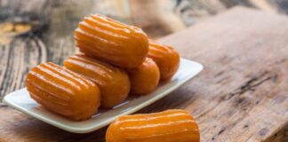 Türk mutfağının en sevilen şerbetli tatlılarından biri olan tulumba, geçmişten günümüze uzanan derin bir kültürel mirası temsil ediyor. Hem sokak lezzetlerinin en ulaşılabilir örneklerinden biri olması hem de sofralarda özel bir yer edinmesiyle tulumba, Türkiye’nin tatlı geleneğinde vazgeçilmez bir yere sahip. Her bölgede farklı bir yorumla hazırlansa da tulumbanın ortak paydası, dışının çıtır içinin ise yumuşak ve gözenekli yapıda olmasıdır. Bu benzersiz özellik, tatlıyı hem hafif hem de doyurucu kılar. Konulu bir haber görseli.