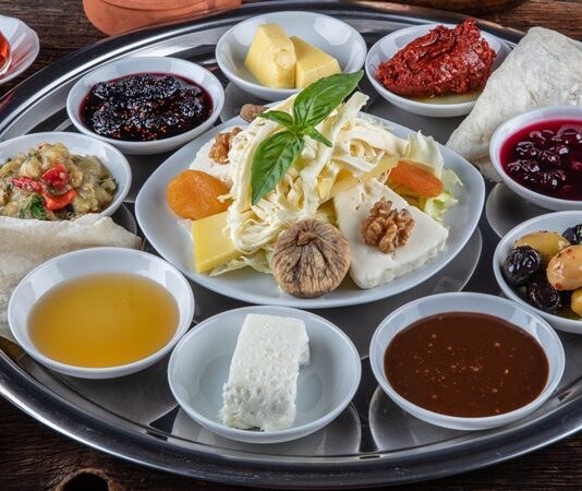 Şehir hayatının yoğun temposundan uzaklaşmak isteyenlerin son yıllarda en çok tercih ettiği gastronomi duraklarından biri köy kahvaltısı mekanları oluyor. Doğal ürünlerle hazırlanan sofralar, sakin ortamlar ve geleneksel tatlar, bu mekanları yalnızca bir kahvaltı noktası değil, aynı zamanda bir deneyim alanı haline getiriyor. Özellikle hafta sonları ailelerin ve arkadaş gruplarının yoğun ilgi gösterdiği köy kahvaltısı mekanları, doğayla iç içe vakit geçirmek isteyenler için güçlü bir alternatif sunuyor. Konulu bir haber görseli.